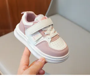 Gros plan de baskets enfant roses et blanches avec cuir synthétique et fermeture velcro