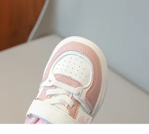 Détail de basket enfant rose et blanc montrant la pointe perforée et les coutures