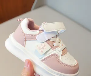 Détail de chaussure de sport enfant rose et blanc avec velcro et zone d'orteil perforée