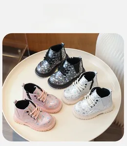 Détail de bottines enfant en cuir verni brillant avec sequins cœur et zip latéral