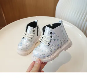 Détail de bottes argentées à cœurs holographiques avec fermeture éclair et semelles épaisses
