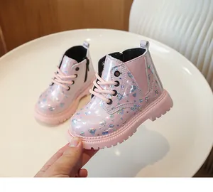 Détail de bottines roses pour filles avec paillettes holographiques et fermeture éclair latérale