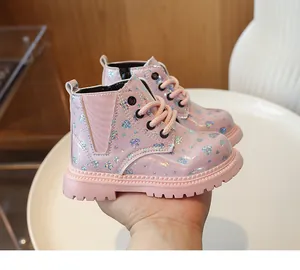 Détail de bottines roses brillantes pour enfants avec motifs cœurs pailletés et semelle épaisse
