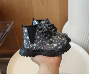 Détail de bottines grises brillantes pour filles avec motifs de cœurs et semelle crantée