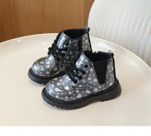 Détail de bottines argentées pour filles avec motifs cœurs pailletés et semelle en gomme