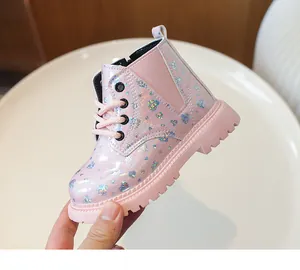 Détail de bottines roses vernies pour enfants avec motifs cœurs pailletés et fermeture éclair