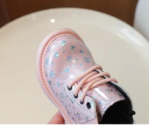 Détail de bottines roses pailletées pour filles avec motifs de cœurs argentés et semelle