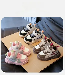 Detailoverzicht van kindersneakers in roze, zwart en bruin met klittenbandsluiting