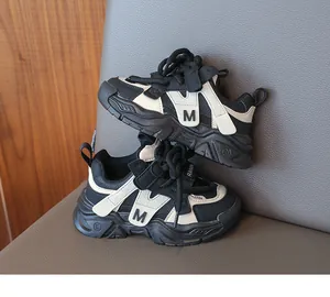 Détail de baskets enfant légères au design bicolore noir et blanc avec logo M décoratif