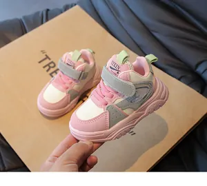 Detail van roze en groene kindersneakers met handige klittenbandsluiting erop