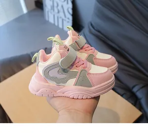 Detailopname van roze en witte kindersneakers met klittenbandsluiting en antislipzool