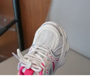 Dettaglio delle scarpe da ginnastica bianche da bambina in mesh con inserti rosa