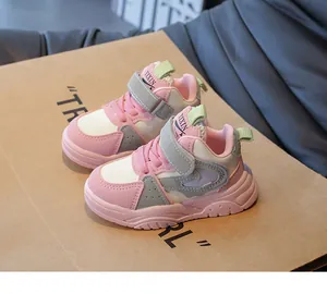 Detail van roze-witte kindersneakers met klittenbandsluiting en een dikke rubberen zool