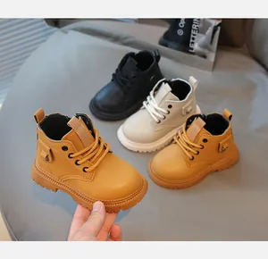 Dettaglio di stivali in pelle per bambini in giallo, beige e nero con suole antiscivolo