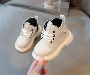 Dettaglio di stivaletti beige per bambini con cerniera laterale e suola in gomma flessibile