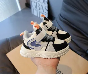 Detail van sportieve kindersneakers met oranje treklussen en dikke antislip witte zolen