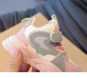 Detail van roze en beige kindersneaker met klittenbandsluiting en synthetisch leer