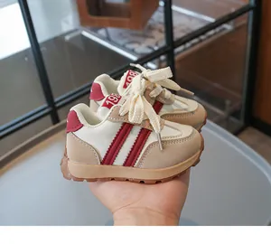 Nahaufnahme der Baby-Sneaker mit 1984-Etikett, beige-rotem Stoff und Gummisohle
