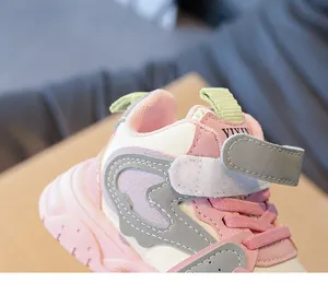 Detailopname van roze meisjessneakers met klittenbandsluiting en stevig leertextuur