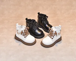Detail view of children's leather Martin boots in black and beige with non-slip rubber soles