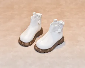 Detail of white leather boots for children showing durable thick rubber soles and stitching