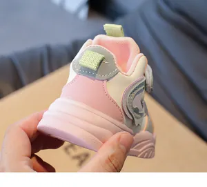 Detail van roze en crèmekleurige hoge kindersneakers met klittenbandsluiting