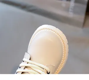 Primo piano di stivaletti in pelle beige per bambini con suole spesse antiscivolo