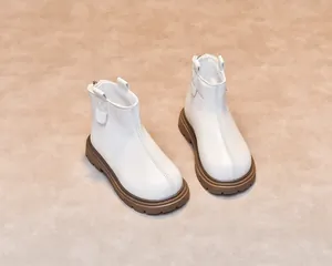 Detail view of white leather toddler boots with brown rubber soles and zip closure