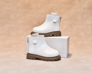 Detail of white kids leather boots featuring rear zipper and durable rubber sole