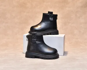 Detailed close-up of kids black leather chelsea boots with non-slip thick rubber soles