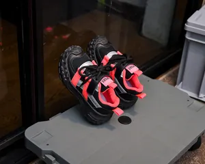 Détail de chaussures de sport enfant noir et rose avec maille respirante et bandes réfléchissantes