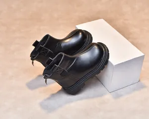 Detail showing the side zipper and thick non-slip rubber sole of black children's boots