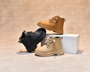 Détail de bottines pour enfants en noir, marron et beige avec semelles en caoutchouc