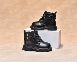 Detail view of children's black leather Martin boots with side zipper and metal C-buckle