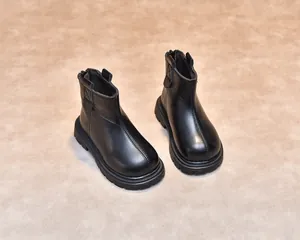 Overhead view of children's black leather boots with anti-slip rubber soles and back zipper