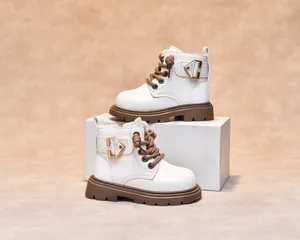 Detail of white leather children boot with thick brown sole and fashion metal buckle