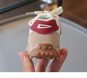 Nahaufnahme der Kinderschuhe in Beige mit rotem Fersenpatch und rutschfester Gummisohle