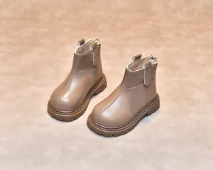 Detail of brown leather kids boot showing reinforced stitching and thick rubber sole