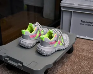 Détail de la chaussure de sport enfant en maille grise respirante et accents néon