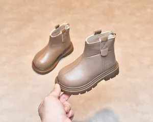 Detailed view of kids' brown leather boots with side zipper and non-slip rubber sole