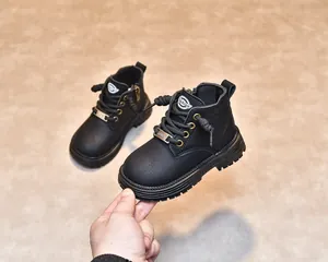 Vue détaillée des bottines en cuir noir pour enfants avec semelles antidérapantes et œillets
