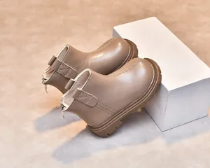 Detail of children's tan leather boots featuring back zipper closure and thick rubber soles