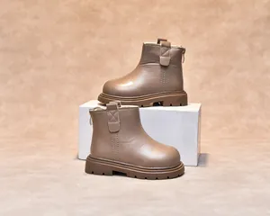 Detailed view of children's brown leather boots featuring rear zipper and thick rubber sole