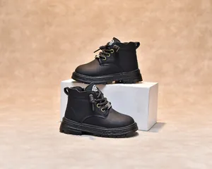 Gros plan sur les bottines noires pour enfants montrant la texture du cuir et les logos