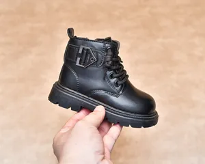 Detailed view of kids' black matte boots with metal buckle and anti-slip rubber sole