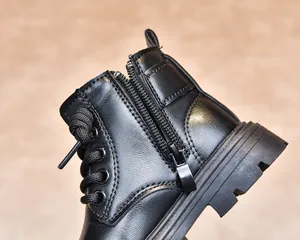 Detailed view of the side zipper and premium leather texture on black kids boots