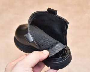 Detail view of children's black Martin boots showing rear zipper and mesh lining