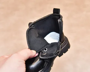 Detail shot of the breathable mesh lining and side zipper of children's black boots