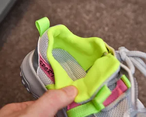 Détail de la maille grise respirante avec doublure vert néon et imprimé Sport