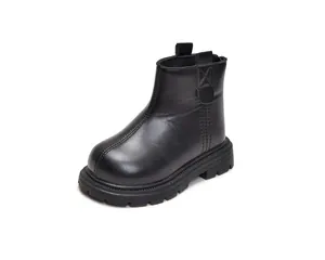 Detailed macro view of black faux leather kids boots with non-slip rubber soles